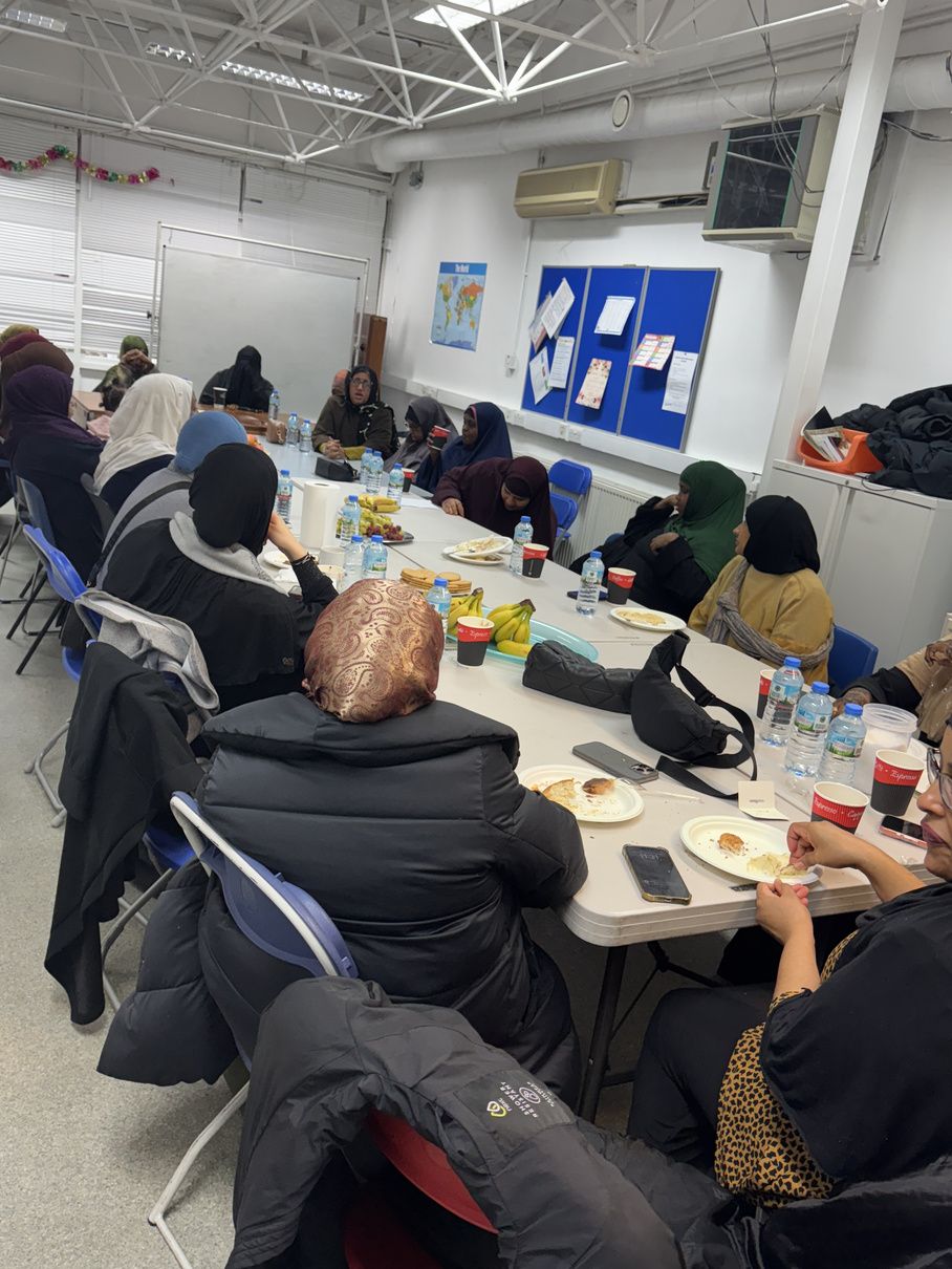 Local women seated around long tables at the Bridge to Work session