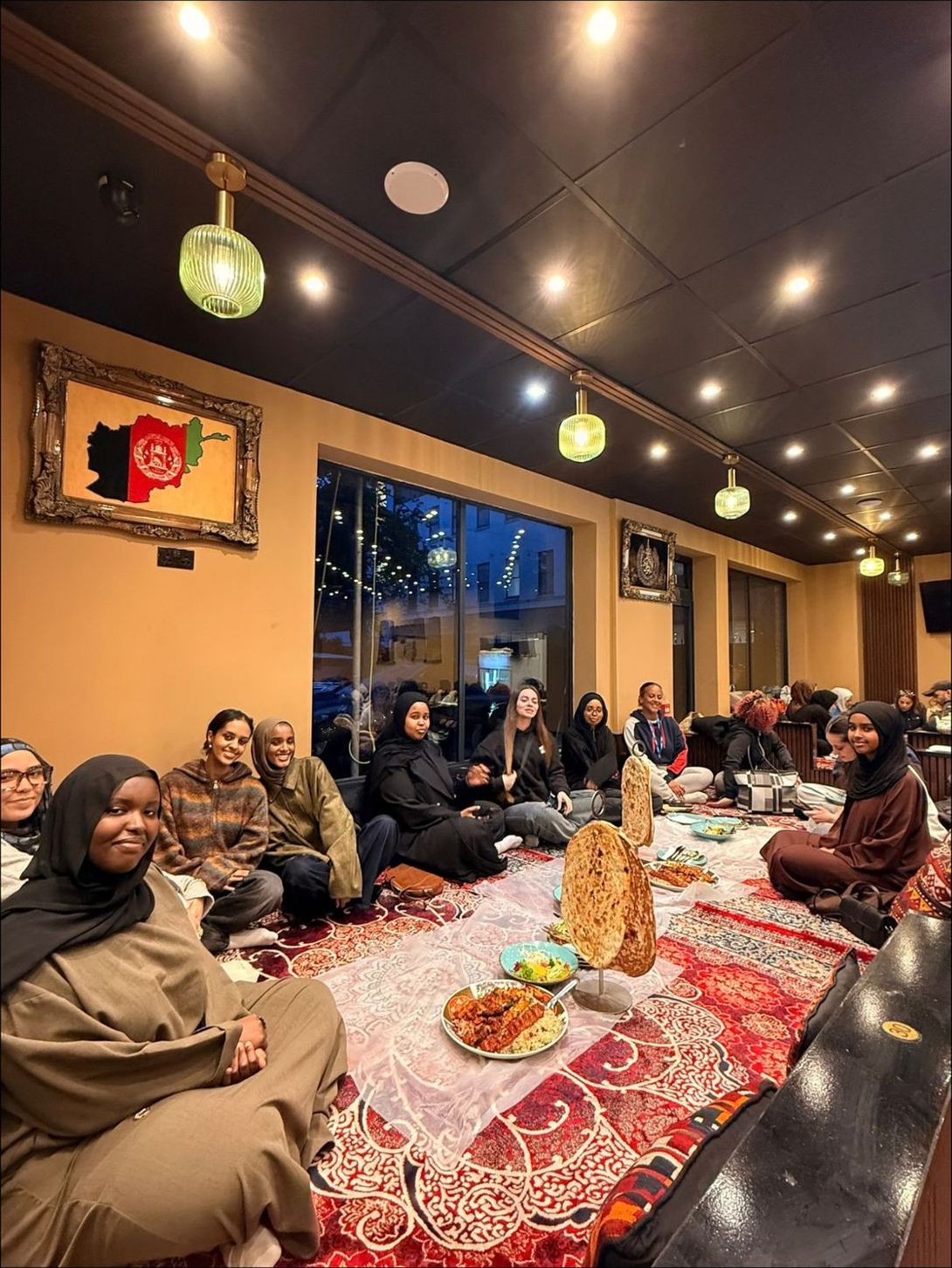 Young women sitting together on floor cushions at a restaurant for dinner
