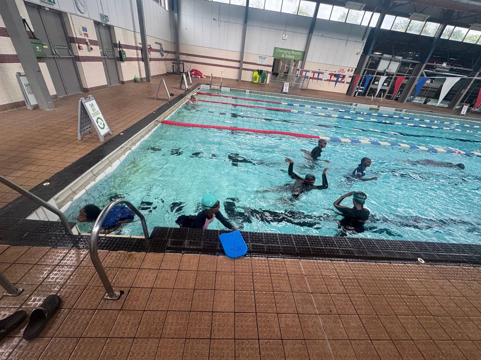 Girls learning to swim in an indoor pool during a private, women-only session