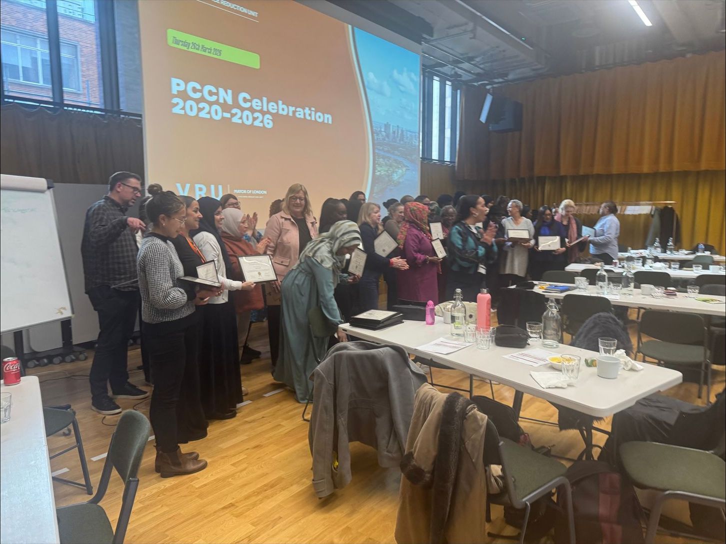 Parent Champions in a hall at the PCCN Celebration, with the event title on the screen